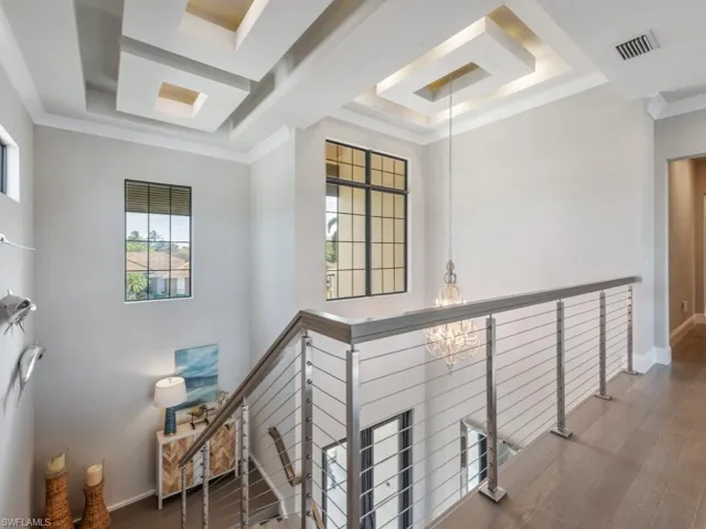 Stairway featuring a raised ceiling and crown molding