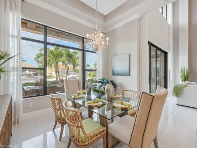 Dining area with a chandelier, a high ceiling, and light tile patterned flooring