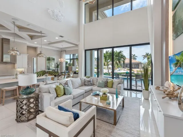 Tiled living room featuring a notable chandelier, a towering ceiling, and coffered ceiling