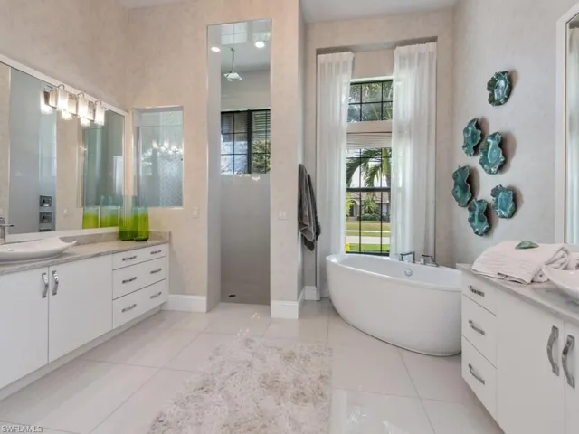Bathroom with tile patterned floors, vanity, and separate shower and tub