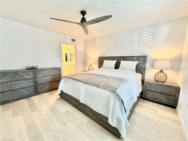 Master Bedroom featuring light wood-style flooring, ensuite bath, and a ceiling fan