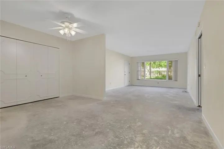 Unfurnished bedroom with concrete flooring, a ceiling fan, and a closet