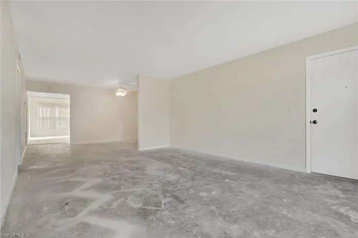 Spare room with unfinished concrete floors and a ceiling fan