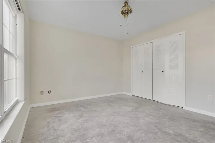 Unfurnished bedroom featuring a closet and unfinished concrete floors