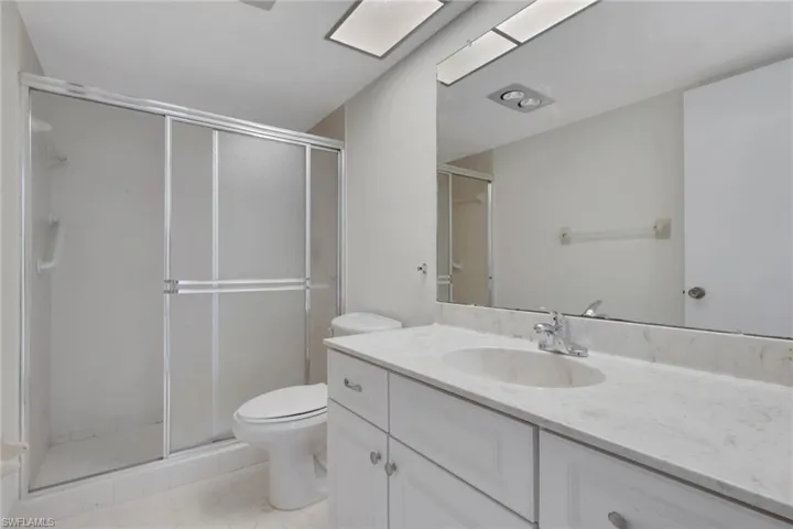 Bathroom featuring vanity, a stall shower, and light tile patterned floors