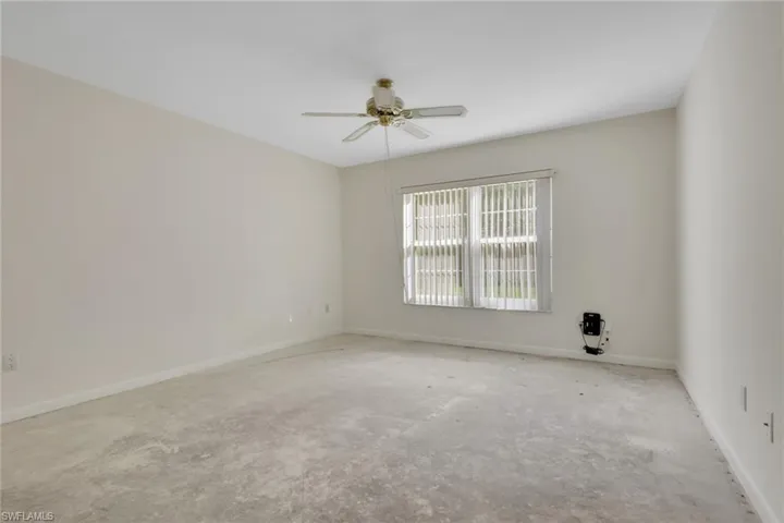 Empty room with a ceiling fan and unfinished concrete floors