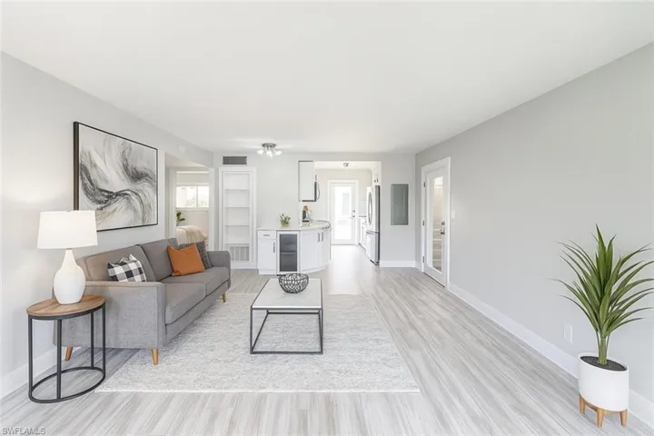 Living area with light wood-style flooring, wine cooler, and electric panel