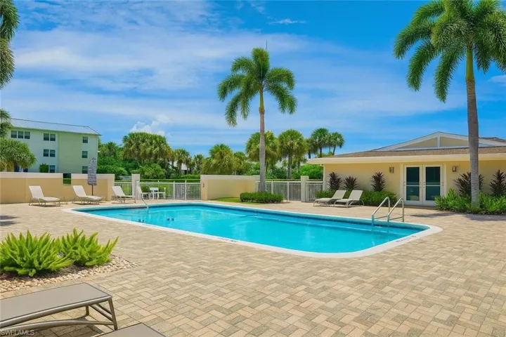 Community pool with french doors and a patio area