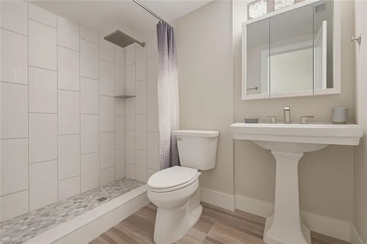 Bathroom with a tile shower and wood finished floors