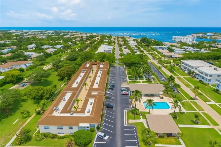 Drone / aerial view of a nearby body of water and a pool area