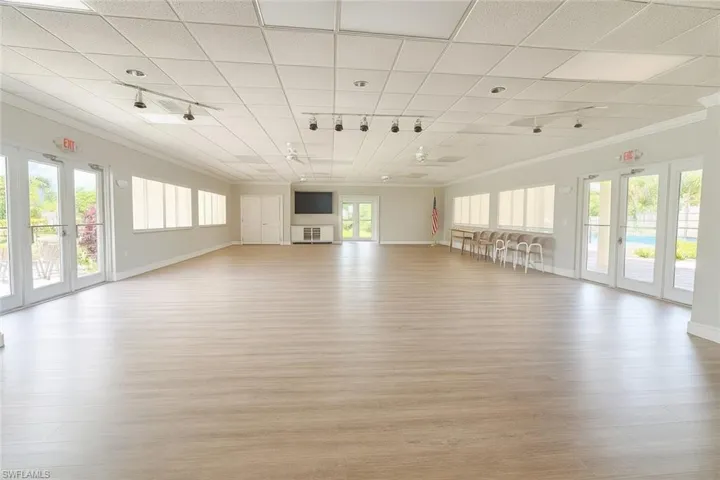 Unfurnished living room featuring crown molding, light wood-style flooring, a paneled ceiling, and rail lighting