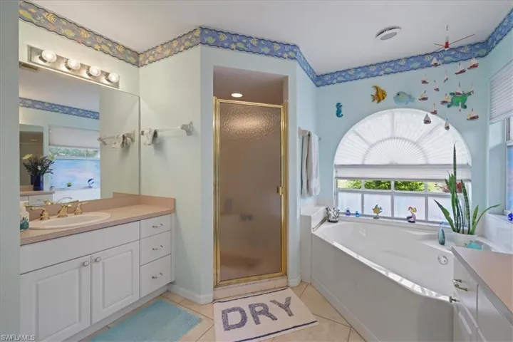 Primary bathroom with double vanities, a garden tub and a stall shower