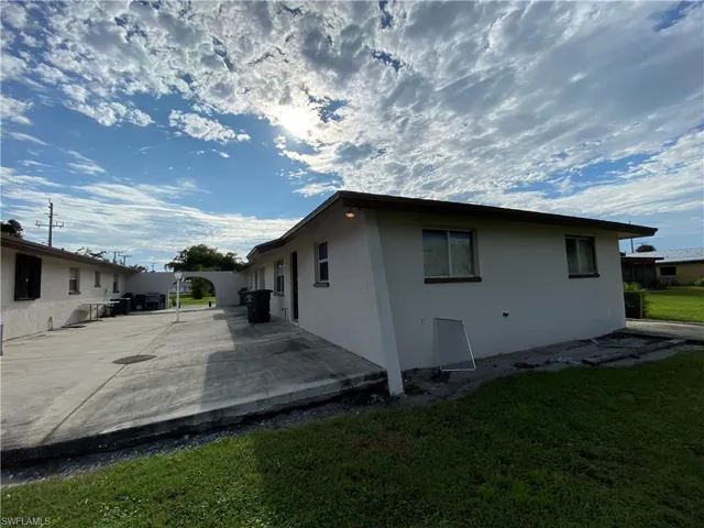 View of home's exterior with a patio area, stucco siding, and a lawn