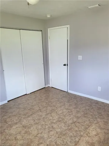 Unfurnished bedroom featuring baseboards and a closet