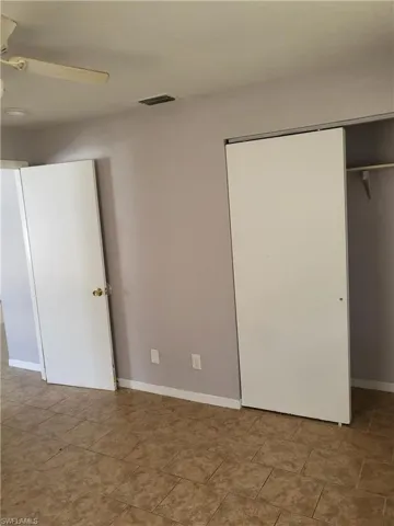 Unfurnished bedroom featuring a ceiling fan and a closet
