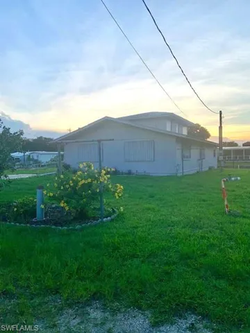 Property exterior at dusk featuring a yard
