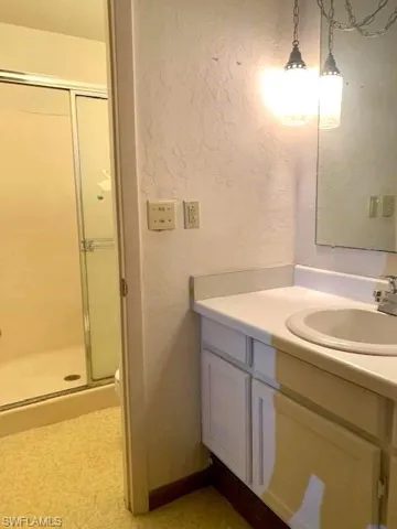 Bathroom with a shower with shower door and vanity