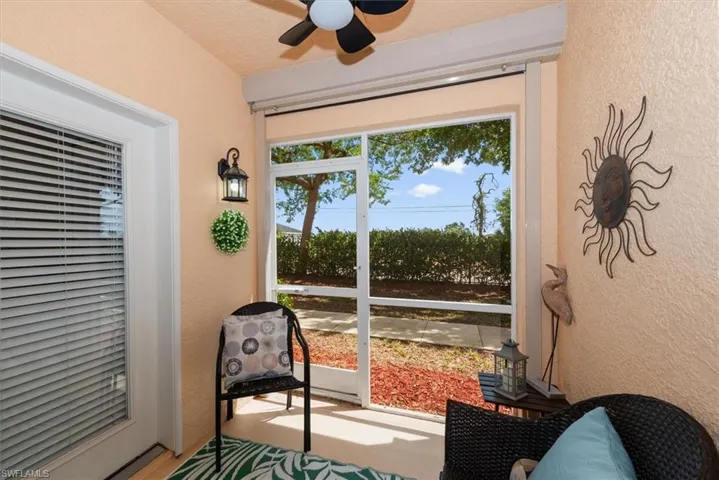 Screened lanai shows door to kitchen, complete w/ceiling fan & seating area!