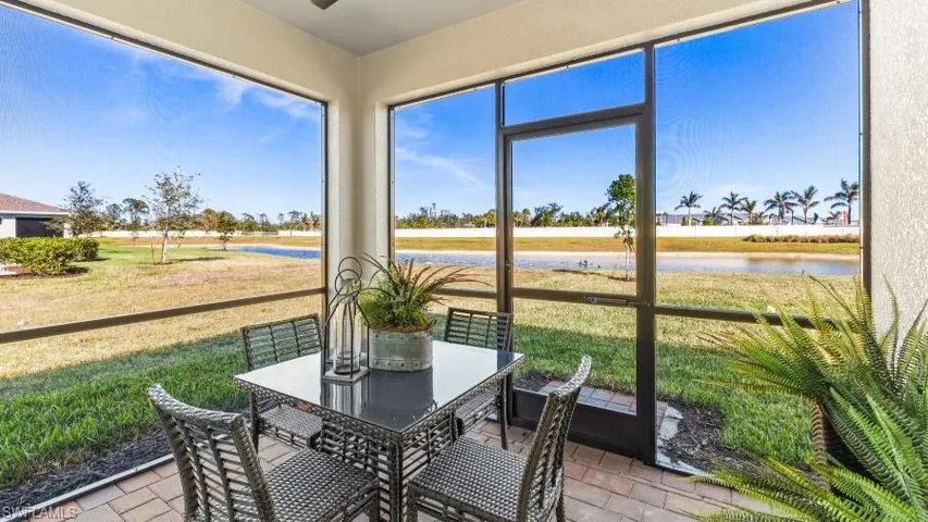 Model Home. The property features a screened patio with brick pavers, offering views of a body of water and distant palm trees
