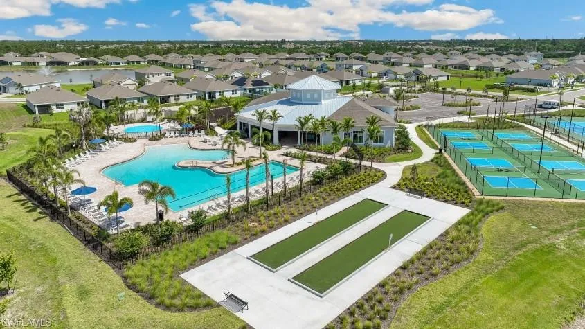 The property features a large outdoor pool with an extensive deck and lounge chairs, surrounded by palm trees