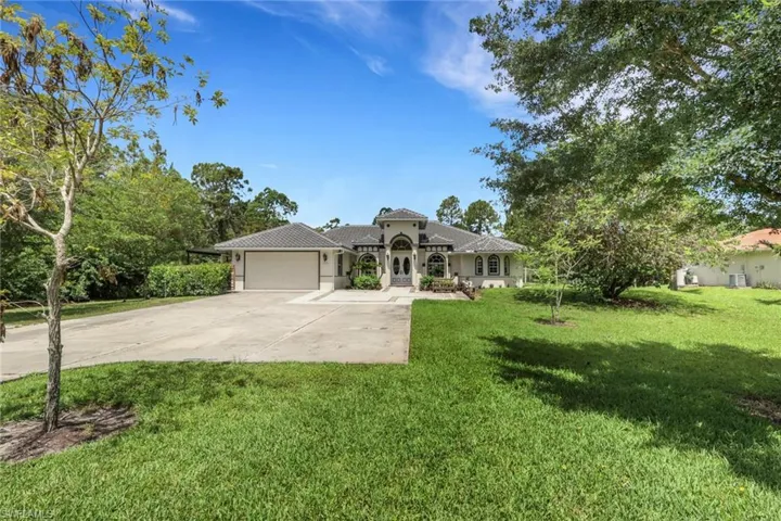Mediterranean-style residence featuring a tile roof, arched entryway, and multiple arched windows