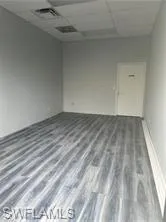 Unfurnished room featuring a paneled ceiling and wood finished floors