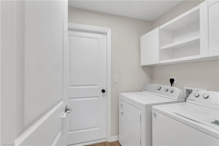 Laundry room featuring cabinets, light wood-type flooring, and washing machine and dryer