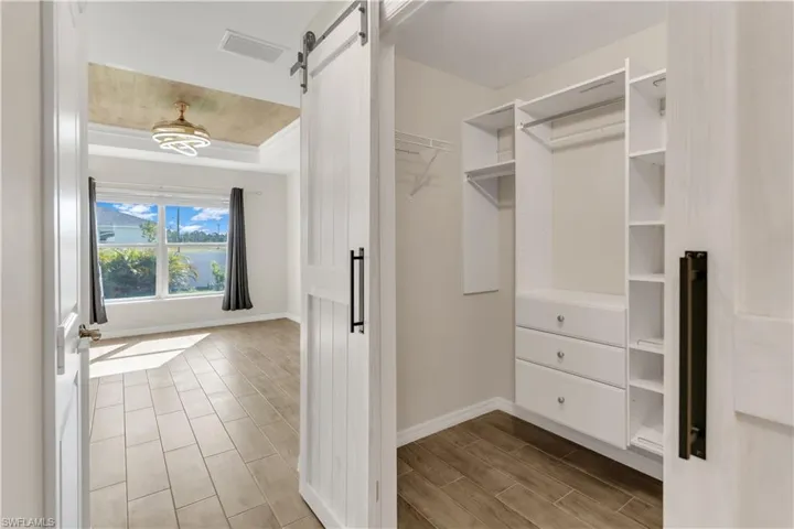 Spacious closet with a barn door and light wood-type flooring