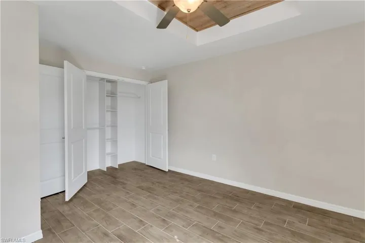 Unfurnished bedroom featuring light hardwood / wood-style flooring, a closet, and ceiling fan