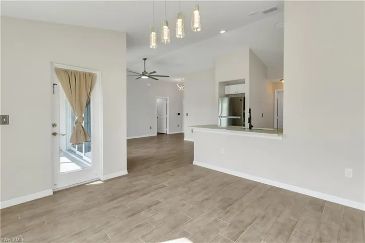 Unfurnished living room with ceiling fan and light hardwood / wood-style flooring