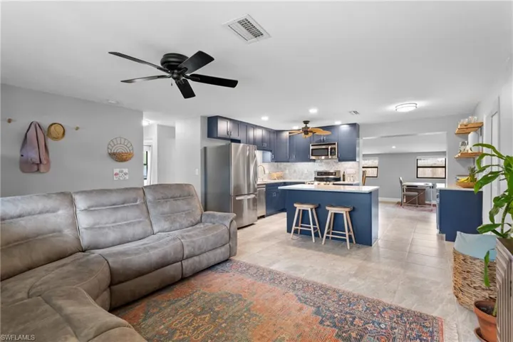 Tiled living room with ceiling fan and sink