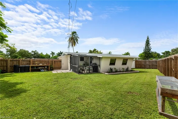 Back of house featuring a yard and a sunroom