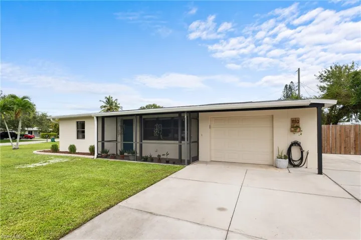 Ranch-style home with a front yard, a garage, and a sunroom