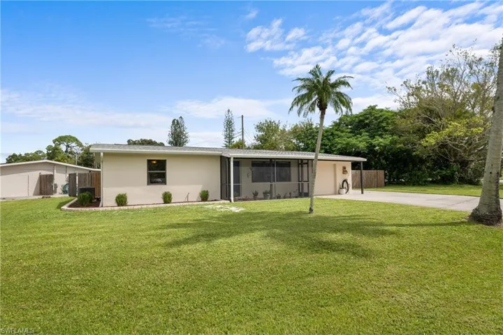 Back of property with a sunroom, a lawn, and a garage