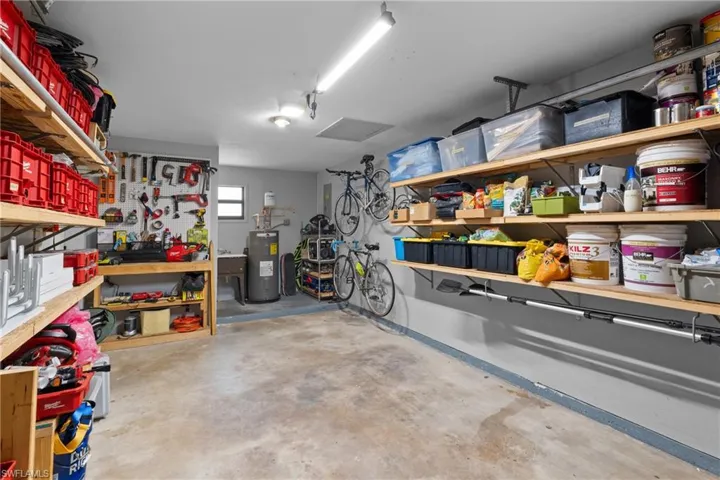 Garage with electric water heater and a workshop area