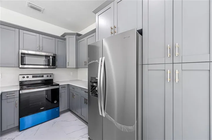 Kitchen featuring stainless steel appliances and gray cabinets