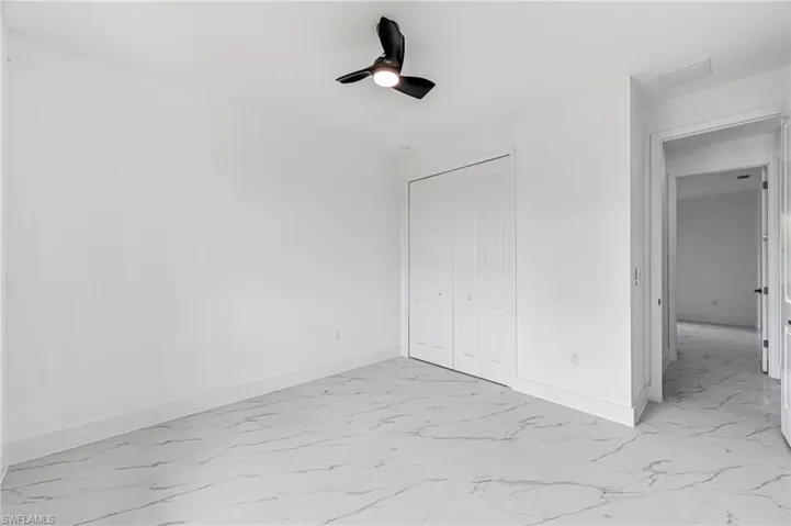 Guest bedroom with ceiling fan and a closet