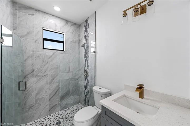 Guest bathroom featuring vanity, toilet, and walk in shower