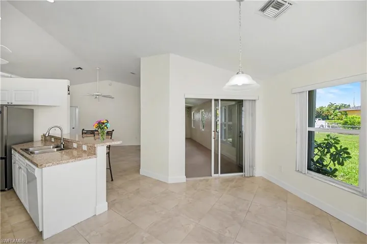 kitchen counter bar or set up dining table under light for breakfast dining with others. Peaceful view outside to your back yard through the window.  The sliding glass doors is the newly built florida room.