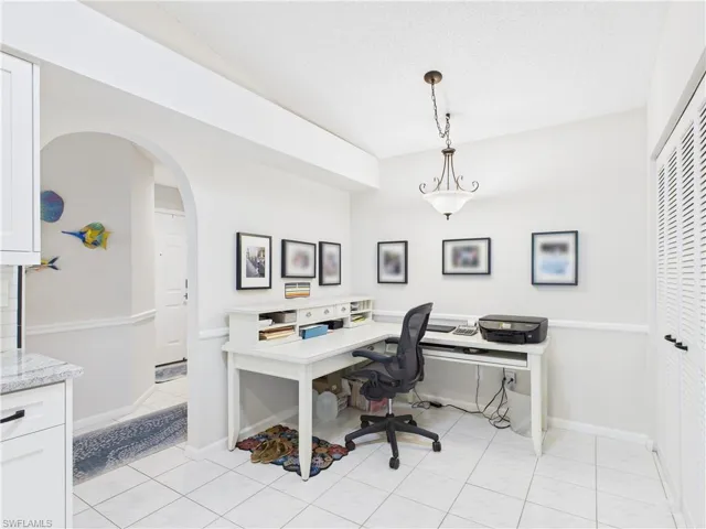 Office with arched walkways and light tile patterned floors