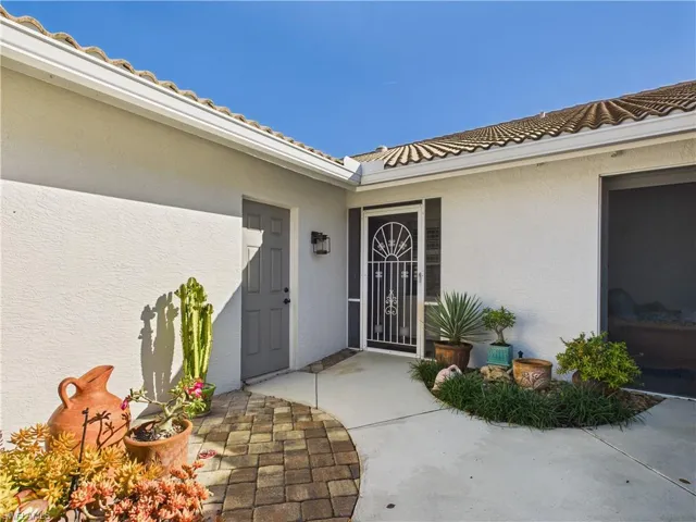 Doorway to property featuring stucco siding