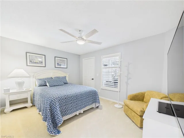 Bedroom with carpet, ceiling fan, and a textured ceiling