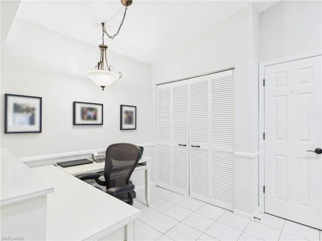 Home office with vaulted ceiling and light tile patterned floors