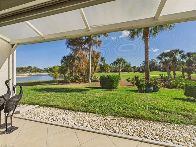 View of green lawn featuring a water view and a patio