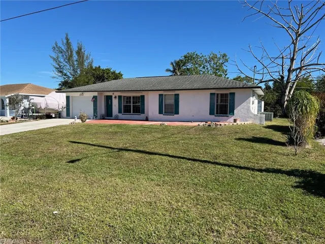 Single story home featuring central AC unit, a garage, and a front lawn