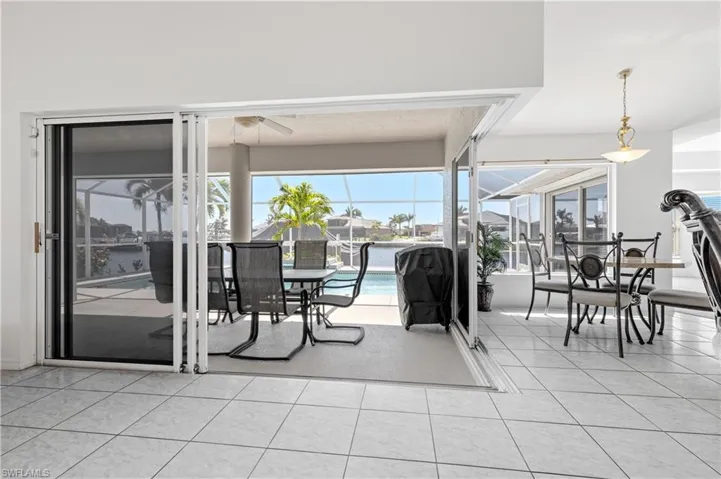 Living room looking out thru 90 degree sliders at pool and canal