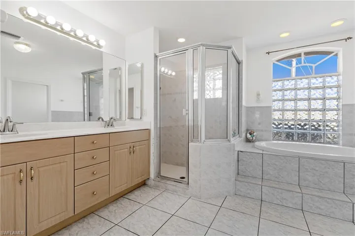 Primary bathroom with dual sink vanity, walk in shower and soaker tub