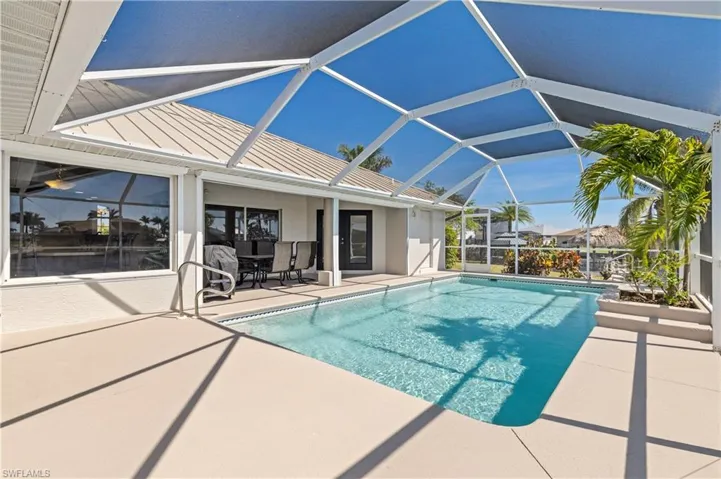 Pool with screened enclosure and a patio area