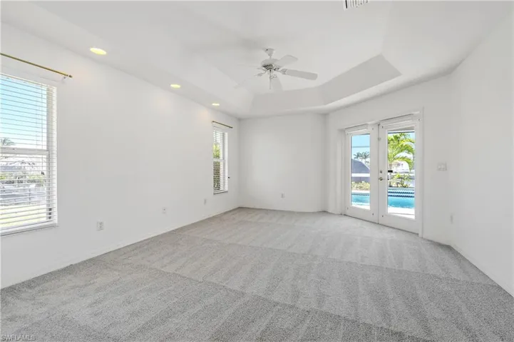 Primary bedroom with french doors out to lanai and pool