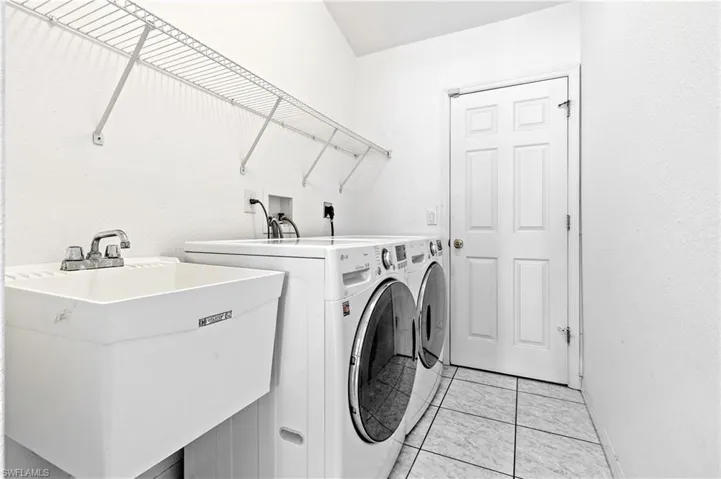 Laundry area with deep sink and storage shelves and closet